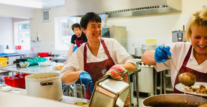 People serving food in community cafe